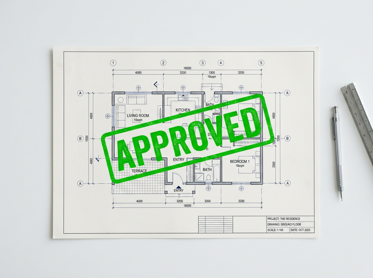 Construction blueprints with a green APPROVED stamp